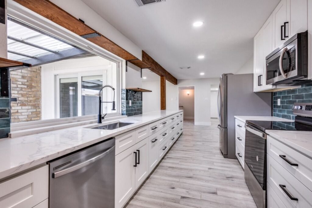 kitchen remodeling in Garland, TX, showcasing a long countertop, open shelving with a farmhouse sink, and a blend of modern and rustic design elements