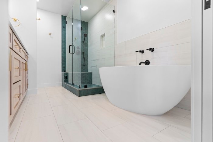 This modern double vanity with round mirrors and matte black fixtures was part of a recent bathroom remodel in Allen, TX.