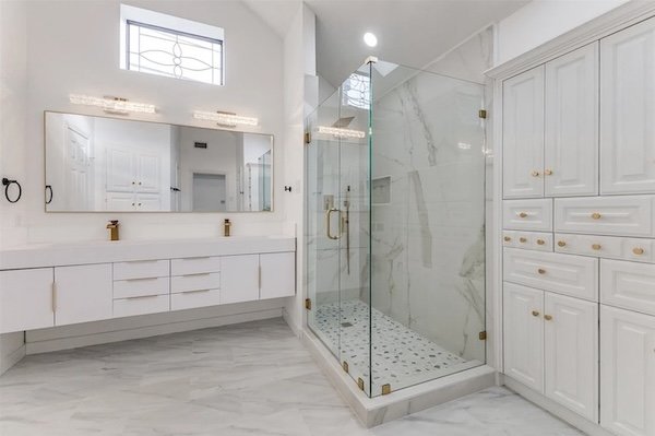 Glass-enclosed walk-in shower remodel in Richardson, Texas with marble-style tile